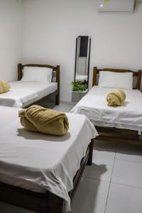 2 Betten mit gelben Kissen auf einem Zimmer in der Unterkunft Guajira Sunset Hostal in Ríohacha