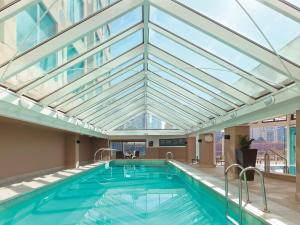 uma piscina com tecto de vidro em The Langham Melbourne em Melbourne