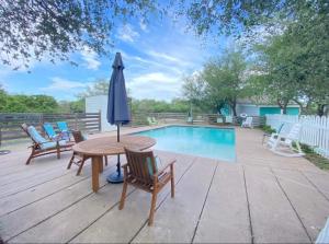 a patio with a table and umbrella next to a pool at Seaside Retreat in Rockport