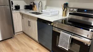 a kitchen with a stainless steel stove and refrigerator at Peaceful basement, Calgary city in Calgary