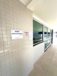 una parete bianca di maiolica in un edificio con dei cartelli di Apartamento até 8 Pessoas Praia Grande - Le Bon Vivant ad Arraial do Cabo