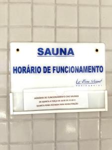 a sign on a tiled bathroom wall with a sign for samara horomo at Apartamento até 8 Pessoas Praia Grande - Le Bon Vivant in Arraial do Cabo