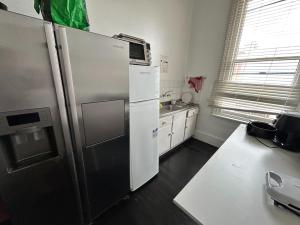 a kitchen with a stainless steel refrigerator and a sink at Rob Roy Room 1 in Adelaide