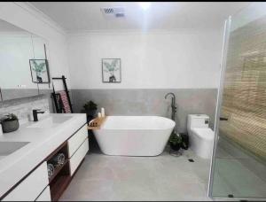 baño con bañera grande y aseo en Edgewater Whole Holiday Resort, en Perth