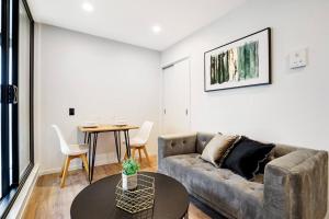 a living room with a couch and a table at Modern 1-Bedroom City Centre in Auckland