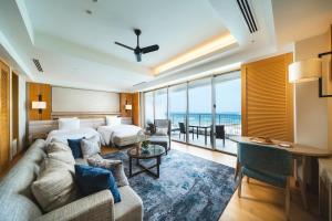 a hotel room with a couch and a bed at The Orion Hotel Motobu Resort & Spa in Motobu
