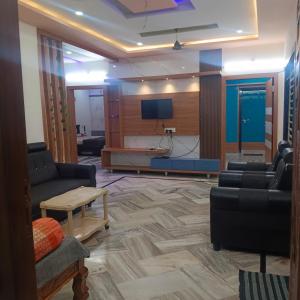 a living room with couches and a flat screen tv at Karthikeya villa’s in Narasaraopet