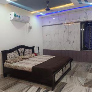 a bedroom with a bed and a white wall at Karthikeya villa’s in Narasaraopet