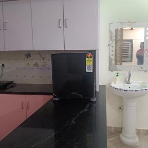 a black refrigerator in a kitchen with a sink at Karthikeya villa’s in Narasaraopet