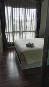 a bedroom with a bed with two shoes on it at Otto Stay BKK airport 10 mins, Near Malls & Night Market in Ban Khlong Lat Bua Khao