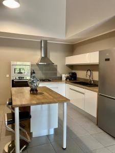 a kitchen with a wooden table and a refrigerator at chez Gérald in Noumea