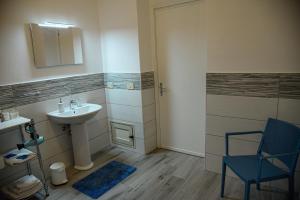 ein Badezimmer mit einem Waschbecken und einem blauen Stuhl in der Unterkunft Kalsa Casa dei Mori in Palermo