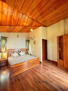 a bedroom with a large bed in a room with wooden ceilings at Mysa by Meraki - Entire Villa with Himalayan Views in Rānīkhet
