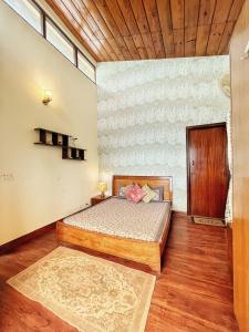 a bedroom with a bed and a wooden ceiling at Mysa by Meraki - Entire Villa with Himalayan Views in Rānīkhet