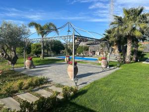 a group of vases with flowers in them in a park at Casa Vacanze Villa di Loreto - Uso Esclusivo in San Giovanni la Punta