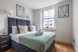 a bedroom with a large bed with a teddy bear on it at Central Fitzrovia - CityApartmentStay in London