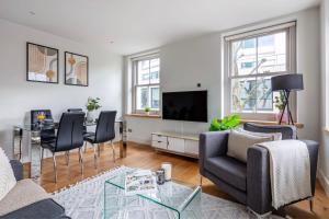 a living room with a couch and a table at Central Fitzrovia - CityApartmentStay in London