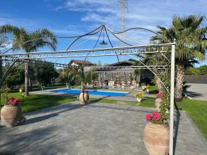 an archway with flowers in pots in a yard at Casa Vacanze Villa di Loreto - Uso Esclusivo in San Giovanni la Punta
