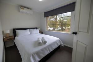 um quarto com uma cama branca e uma janela em Urban Oasis Hideaway em Perth