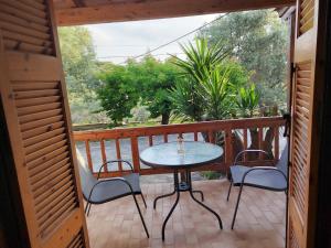 a patio with a table and chairs on a balcony at Olive Garden Loft Apartment in Kokkari