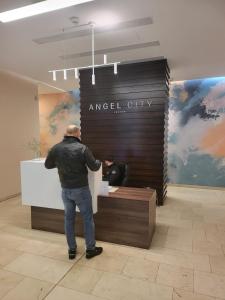 a man standing at a counter in a lobby at AMBER APARTAMENT SZLAK 106 in Krakow