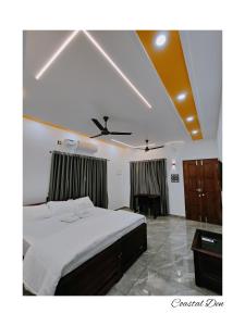 a bedroom with a bed and a desk in it at Coastal Den Homestay in Pallipuram
