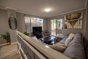 a living room with a couch and a tv at Urban Oasis Hideaway in Perth