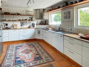 eine Küche mit weißen Schränken und einem Teppich auf dem Boden in der Unterkunft Holiday home ASKIM III in Askim