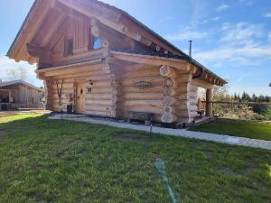 uma cabana de madeira com um telhado num campo de relva em Böhmerwald Lodges em Ulrichsberg