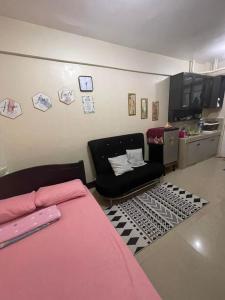 una camera con letto e divano e una cucina di Jen's place ad Antipolo