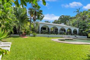 a house with a garden and a grass yard at Ohana Palm Cove in Palm Cove