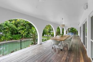 a wooden deck with a table and chairs on a balcony at Ohana Palm Cove in Palm Cove