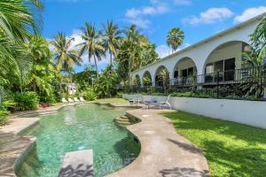 a swimming pool in the backyard of a house at Ohana Palm Cove in Palm Cove