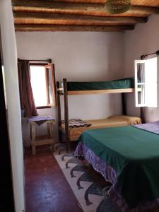 a bedroom with two bunk beds and a window at willkasunco Casa Hospedaje in Amaichá del Valle