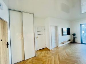 Horizon Park 9 Boszkowo في بوزكوفو: غرفة فارغة بجدران بيضاء وأرضية خشبية
