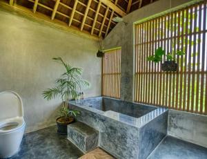 a bathroom with a bath tub and a toilet at Ubud Terrace by Betterplace in Ubud +35 photos