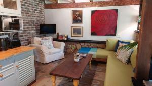 a living room with a couch and a table at Lacebark Cottage in Hilton