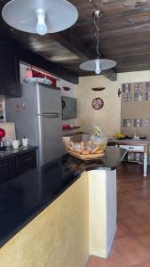 una cucina con piano di lavoro nero e frigorifero di SteMar B&B Casa Completa a Luras