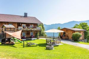 a house with a yard with a table and an umbrella at Bergchalet am Hochkönig in Mühlbach am Hochkönig