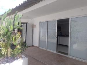 Cette chambre dispose de portes coulissantes en verre et d'une terrasse. dans l'établissement Guajira Sunset Hostal, à Ríohacha