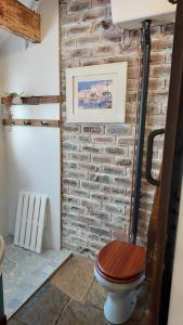 ein Badezimmer mit einer Ziegelwand und einer Toilette in der Unterkunft Lacebark Cottage in Hilton + 12 Fotos
