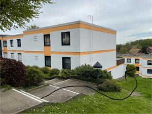 a white and orange building with a parking lot at Küstenperle in Hohwacht