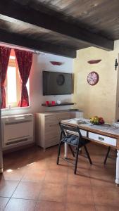 una cucina con tavolo e televisore in una stanza di SteMar B&B Casa Completa a Luras