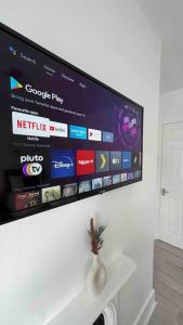 TV de pantalla plana colgada en la pared en King-size bed en- suit, Luxury refurbished home en Balderton