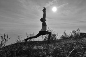 a woman doing a yoga pose on top of a hill at Vedagedara villa in Tangalle
