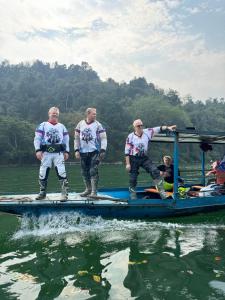 un grupo de hombres parados en un barco en el agua en Anh dược homestay en Bak Kan