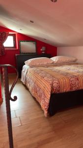 una camera con un letto con una parete rossa di SteMar B&B Casa Completa a Luras