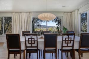 a dining room with a table and chairs and windows at Zen Haus Serene Retreat, prime location with views in Eugene