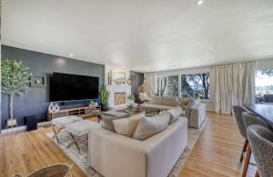 a living room with a couch and a flat screen tv at Zen Haus Serene Retreat, prime location with views in Eugene