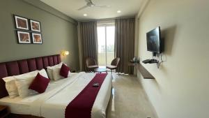 ein Hotelzimmer mit einem Bett und einem TV in der Unterkunft Saltstayz Studio Apartment - Near Artemis & Medanta Hospital in Gurgaon